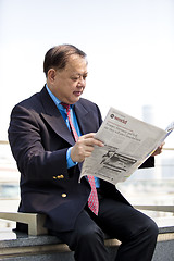 Image showing Asian businessman reading newspaper