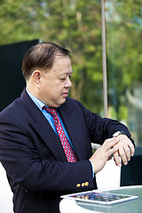 Image showing Asian businessman looking at watch