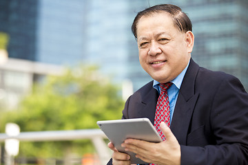 Image showing Asian businessman using tablet