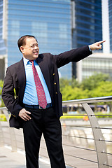 Image showing Asian businessman smiling pointing at a direction