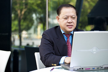 Image showing Asian businessman using laptop