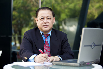 Image showing Asian businessman writing proposal