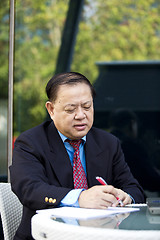 Image showing Asian businessman writing proposa