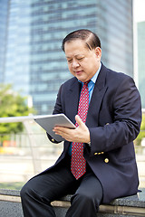 Image showing Asian businessman using tablet