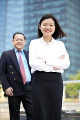 Image showing Asian businessman & young female executive smiling portrait