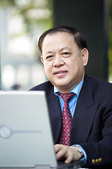 Image showing Asian businessman using laptop