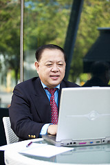 Image showing Asian businessman using laptop