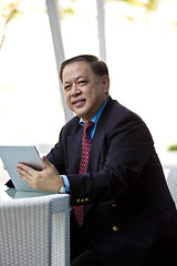 Image showing Asian businessman using tablet