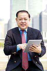 Image showing Asian businessman using tablet