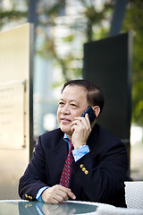 Image showing Asian businessman talking on smart phone