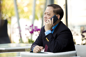 Image showing Asian businessman talking on smart phone