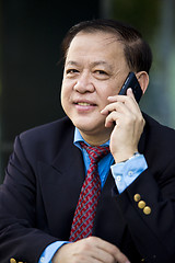 Image showing Asian businessman talking on smart phone