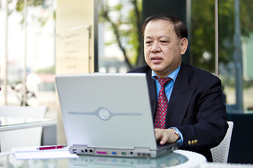 Image showing Asian businessman using laptop