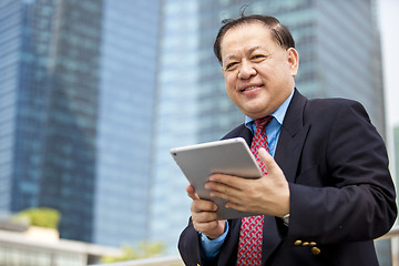 Image showing Asian businessman using tablet