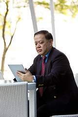 Image showing Asian businessman using tablet