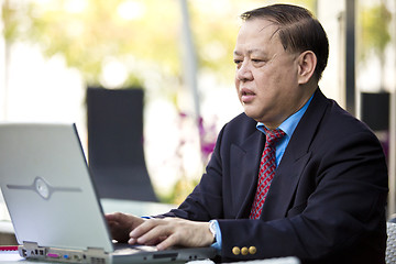 Image showing Asian businessman using laptop