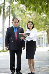 Image showing Asian businessman and young female executive walking