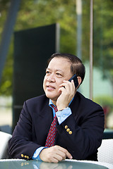 Image showing Asian businessman talking on smart phone