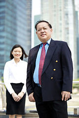 Image showing Asian businessman and young female executive smiling portrait