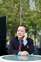 Image showing Asian businessman talking on smart phone