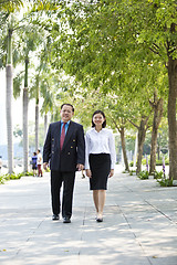 Image showing Asian businessman and young female executive walking