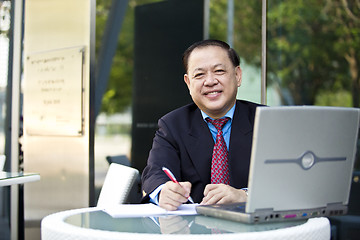 Image showing Asian businessman writing proposal