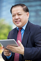 Image showing Asian businessman using tablet