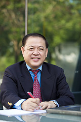 Image showing Asian businessman writing proposal