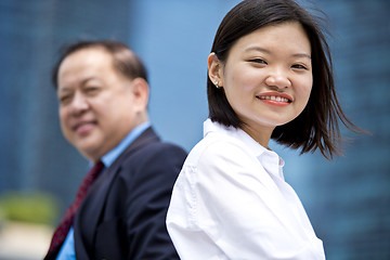 Image showing Asian businessman and young female executive smiling portrait