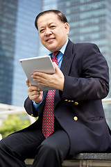 Image showing Asian businessman using tablet