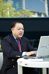 Image showing Asian businessman using laptop