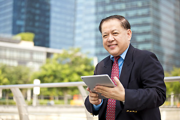 Image showing Asian businessman using tablet