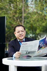 Image showing Asian businessman reading newspaper