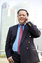 Image showing Asian businessman talking on smart phone