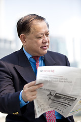 Image showing Asian businessman reading newspaper