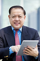 Image showing Asian businessman using tablet