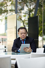 Image showing Asian businessman using tablet