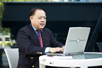 Image showing Asian businessman using laptop