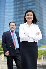 Image showing Asian businessman and young female executive smiling portrait