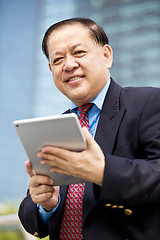 Image showing Asian businessman using tablet