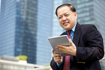 Image showing Asian businessman using tablet