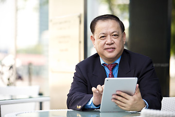 Image showing Asian businessman using tablet