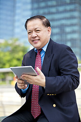 Image showing Asian businessman using tablet