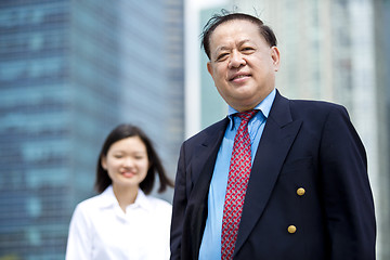 Image showing Asian businessman and young female executive smiling portrait