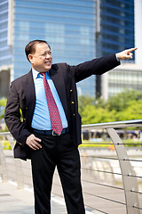 Image showing Asian businessman smiling pointing at a direction