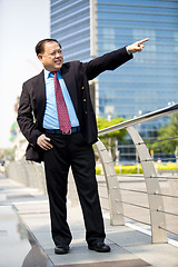 Image showing Asian businessman smiling pointing at a direction