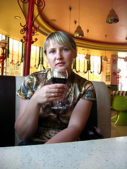 Image showing glass of red wine on the table and women