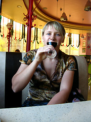 Image showing glass of red wine on the table and a girl