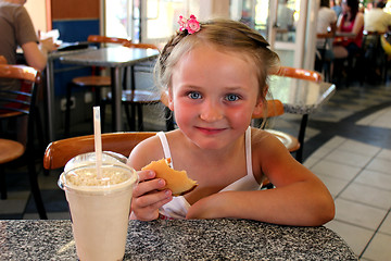 Image showing little beautiful girl having dinner in café