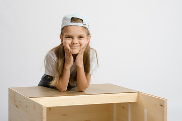 Image showing Portrait a girl leaning on back cover of chest